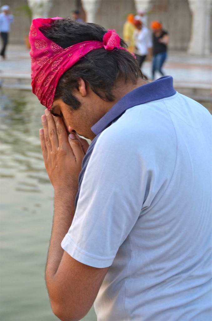 Joven rezando frente al estanque del templo Gurudwara Bangla Sahib. Delhi, India. Copyright Hernando Reyes